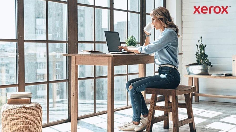 Une femme assise &agrave; un bureau, utilisant un ordinateur portable, faisant preuve de concentration et de productivit&eacute;.