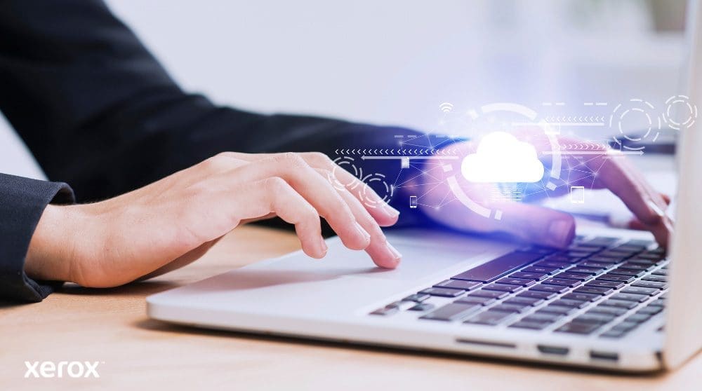 Les mains d'une personne sont repr&eacute;sent&eacute;es en train de taper sur un clavier d'ordinateur portable, avec une ic&ocirc;ne de nuage lumineux et des connexions r&eacute;seau superpos&eacute;es sur l'image, symbolisant la connectivit&eacute; cloud et les flux de travail num&eacute;riques.